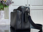 Dark leather crossbody bag side profile with zipper pulls and adjustable strap.