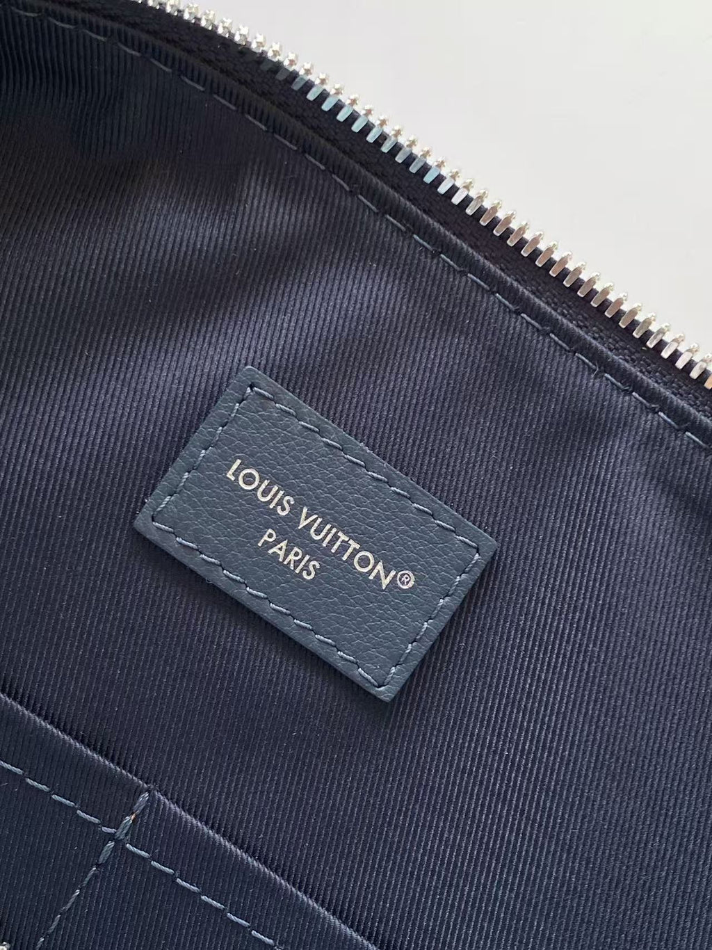 Louis Vuitton Paris label on dark interior pocket with zipper