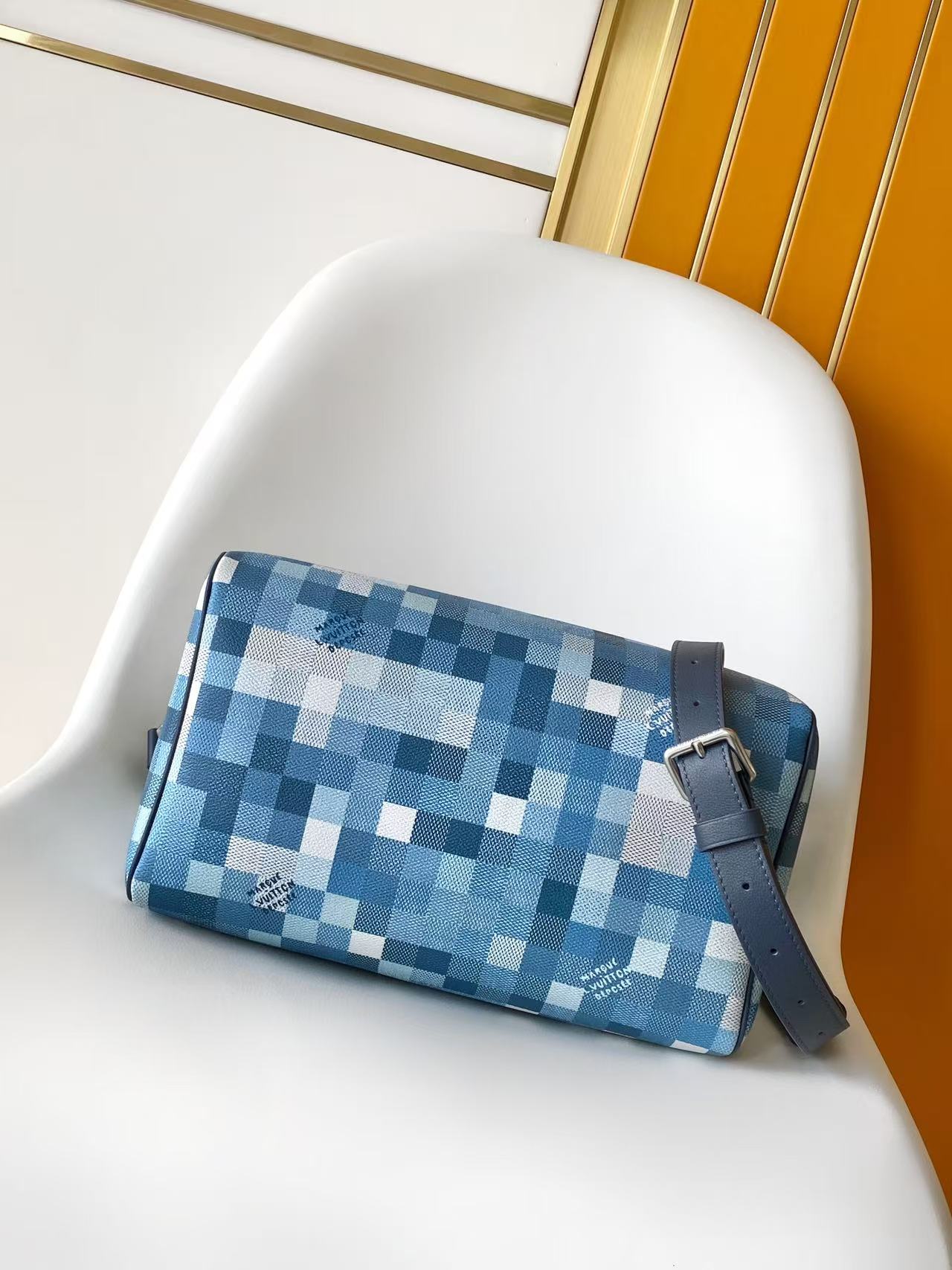 Blue checkered zip handbag with navy crossbody strap and metal buckle