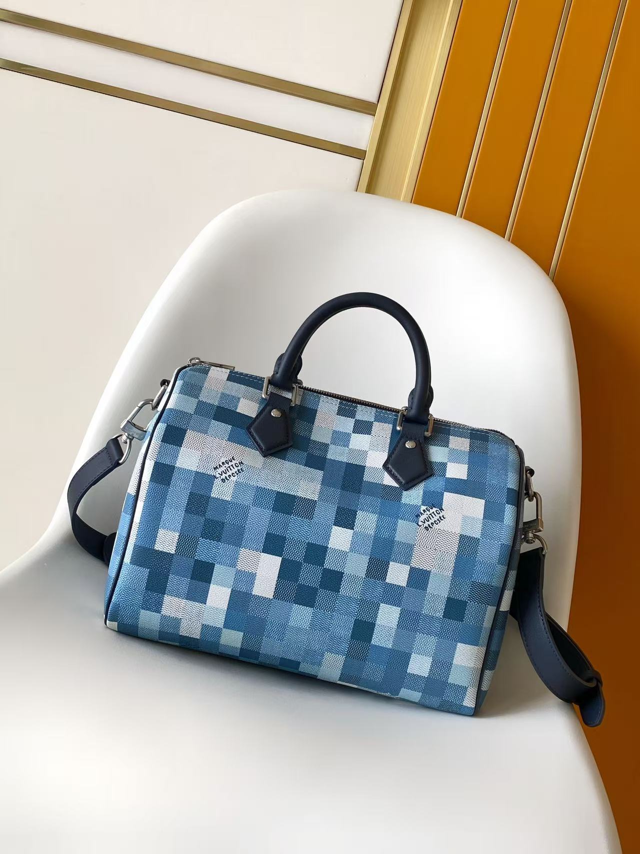 Blue and white checkered handbag with top handles and navy crossbody strap
