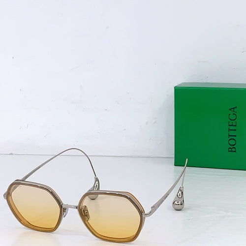 Bottega Veneta sunglasses with yellow tinted lenses and gold-toned metal frame