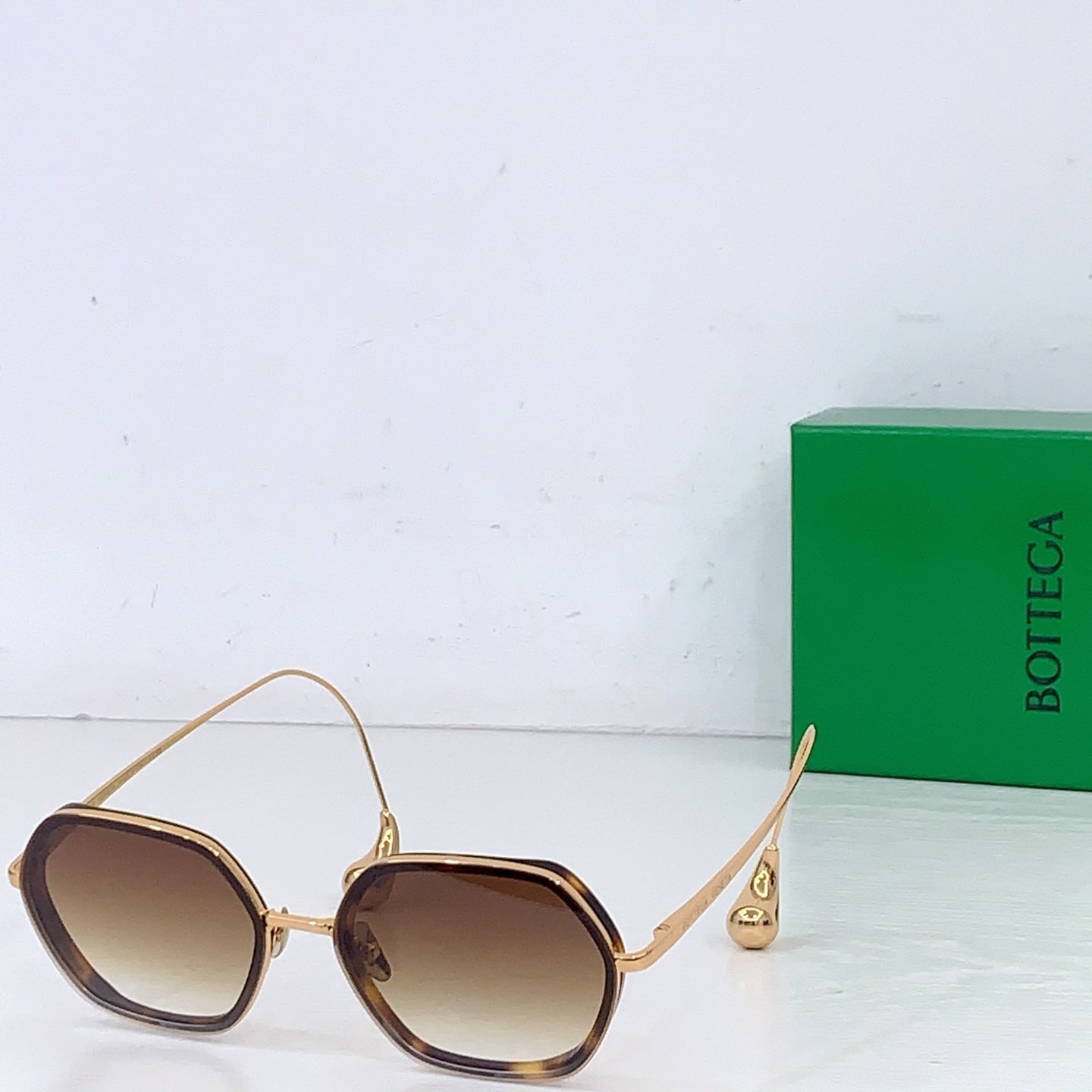 Bottega Veneta sunglasses with dark brown tinted lenses and gold-toned metal frame