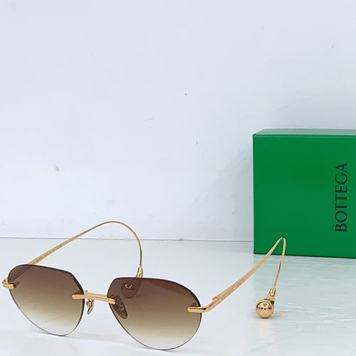 Gold-tone round sunglasses with dark brown gradient lenses and small charm detail