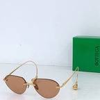 Gold-tone round sunglasses with tan lenses and gold-toned temple tips