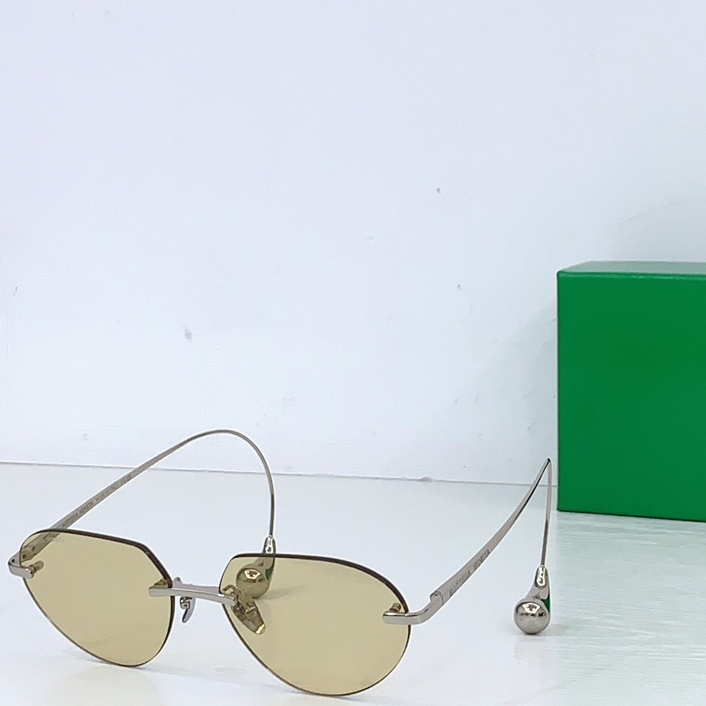 Gold-tone round sunglasses with amber lenses and thin metal temple arms