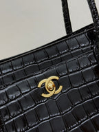 Gold Chanel CC clasp on black croc-texture bag front