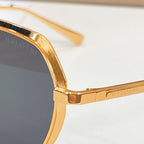 Bvlgari gold sunglasses close-up, round lenses with engraved temple detail