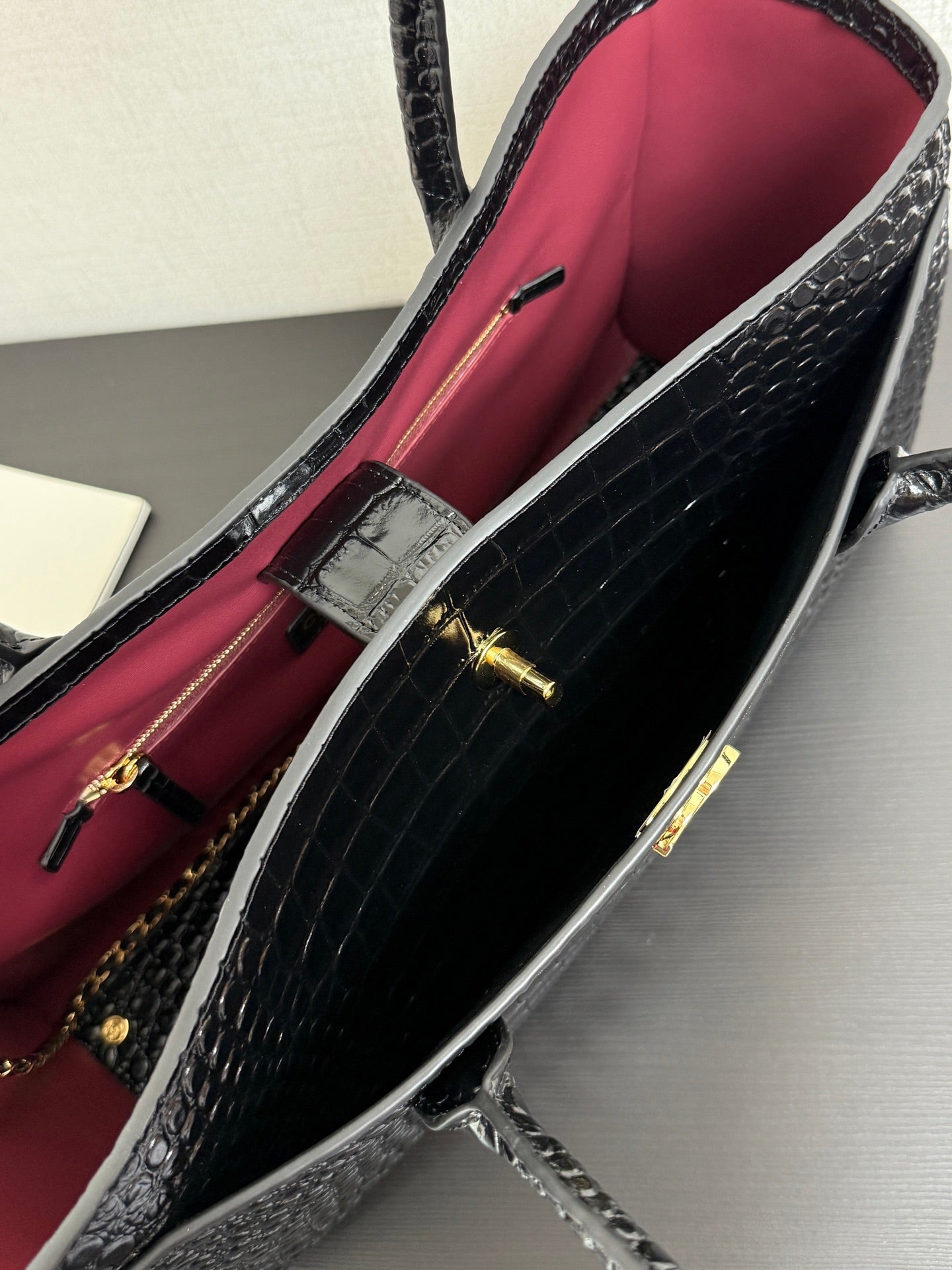 Open bag showing bright pink lining and black croc-texture interior