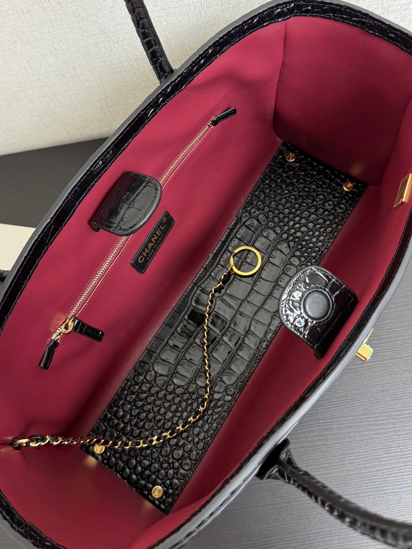 Open Chanel tote with pink lining, zip pocket, and decorative hardware inside