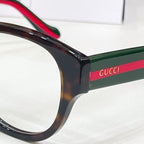 Glasses temple close-up with Gucci logo and green-red stripe detail