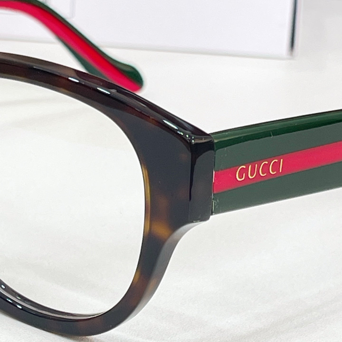 Glasses temple close-up with Gucci logo and green-red stripe detail