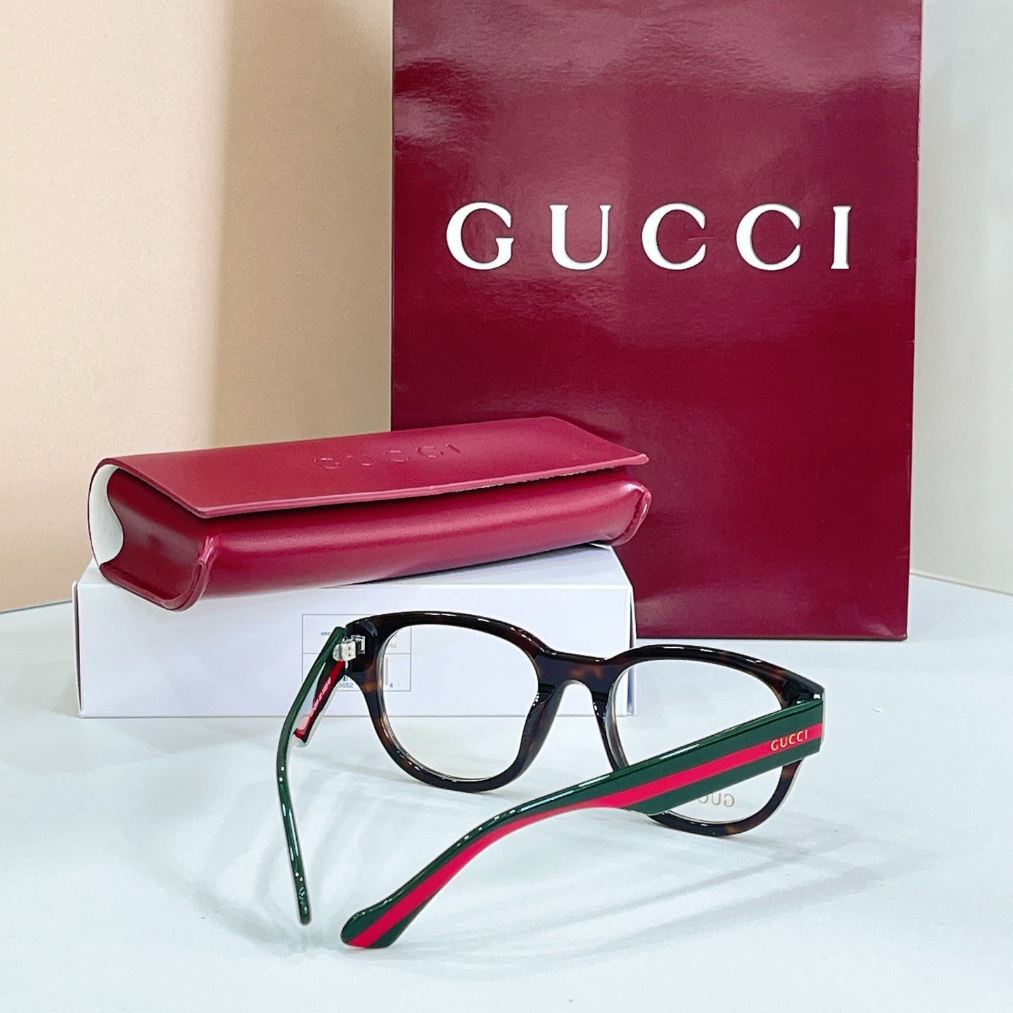 Clear-lens glasses with dark frame and green-and-red striped temple arms
