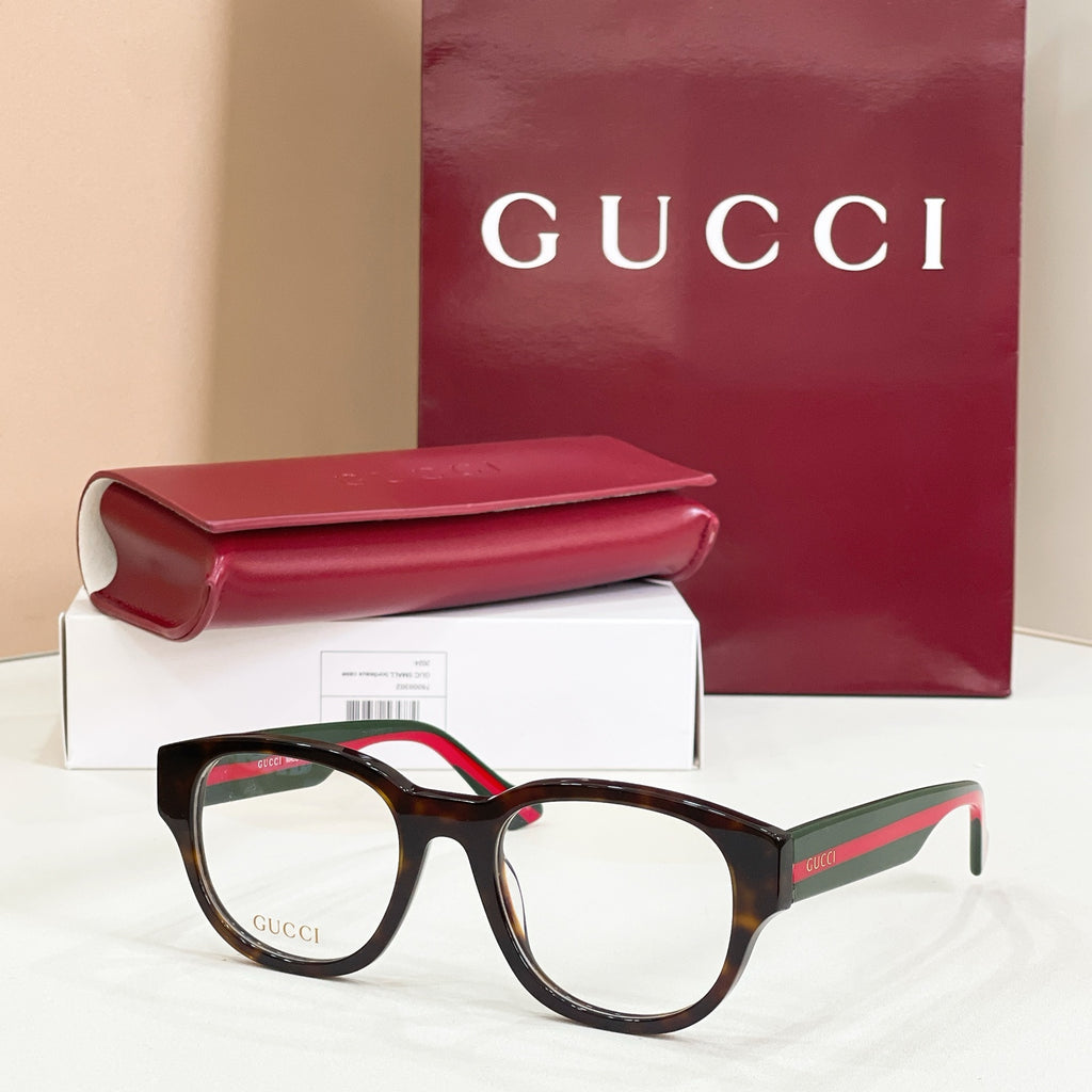 Black acetate glasses with green-and-red striped temples and clear round lenses