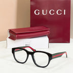 Black acetate glasses with green-and-red striped temples and clear square lenses