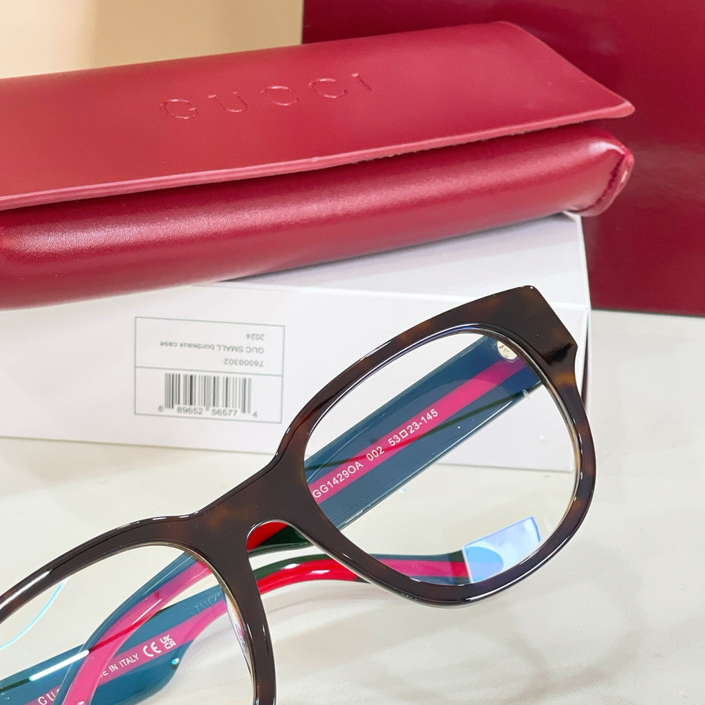 Glasses with dark frame, clear lenses, and green-and-red striped temple arms