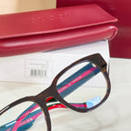 Glasses with dark frame, clear lenses, and green-and-red striped temple arms
