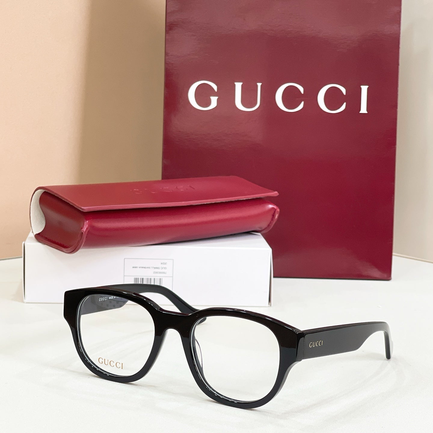 Dark tortoiseshell glasses with green-and-red striped temples and clear lenses