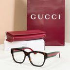 Gucci glasses with dark frames and clear lenses, multicolor temple stripe detail
