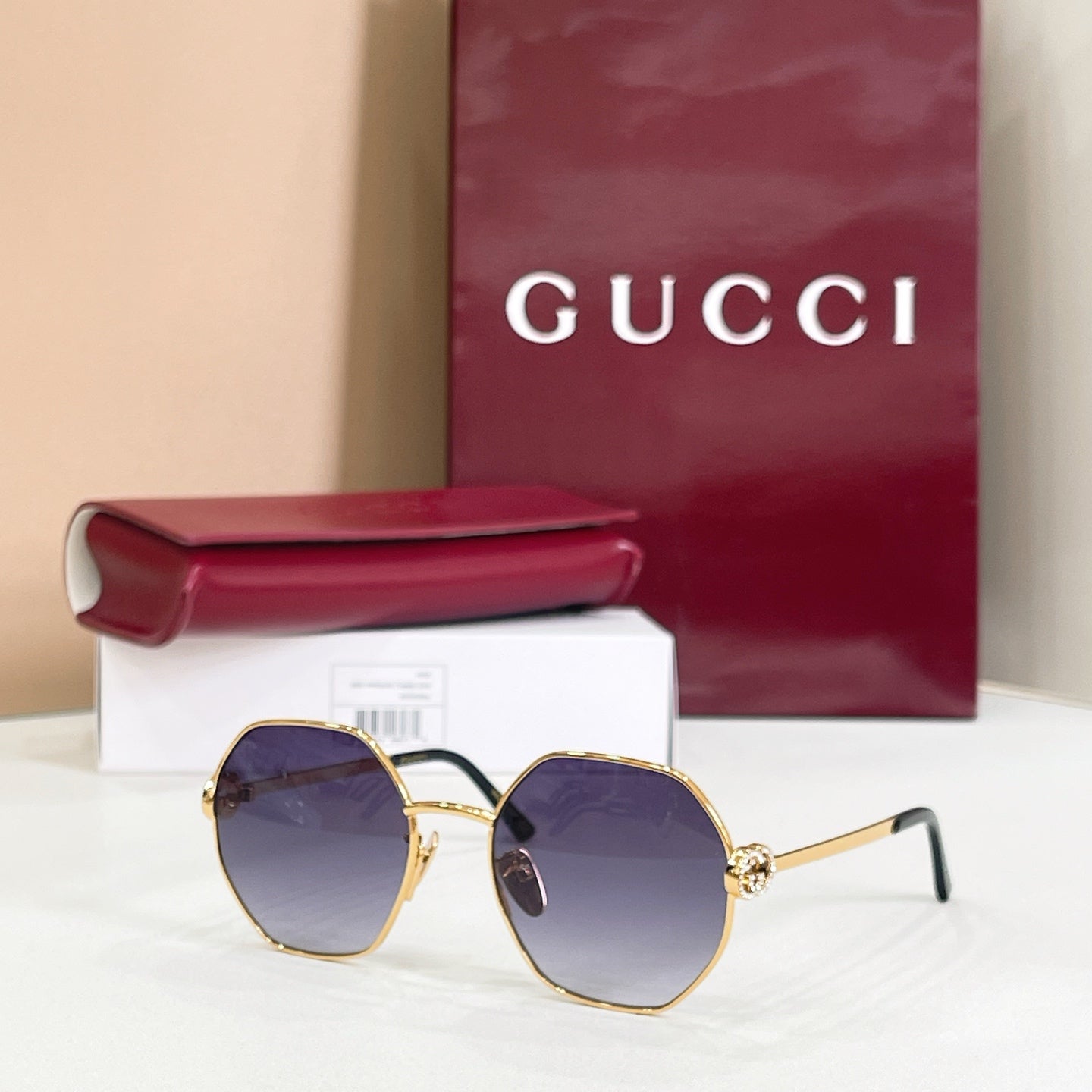 Gucci sunglasses with gold-tone round frames, black arms, dark blue gradient lenses