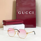 Gucci sunglasses with gold-tone round frames, black arms, pink gradient tinted lenses