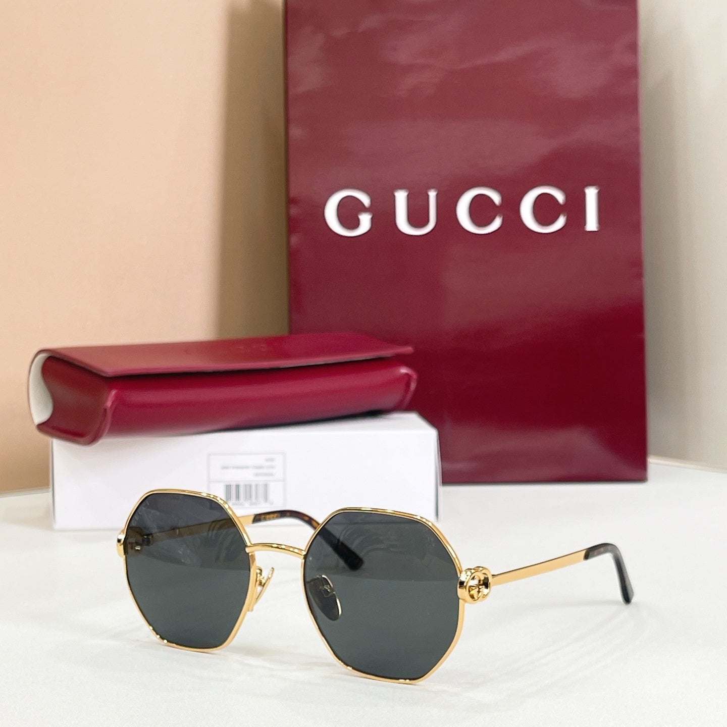 Gucci sunglasses with gold-tone round frames, black arms, dark gray tinted lenses