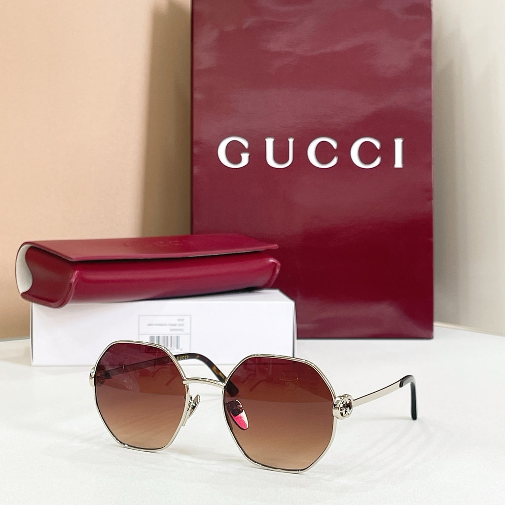 Gucci sunglasses with gold-tone round frames, black arms, brown gradient tinted lenses