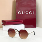 Gucci sunglasses with gold-tone round frames, black arms, brown gradient tinted lenses