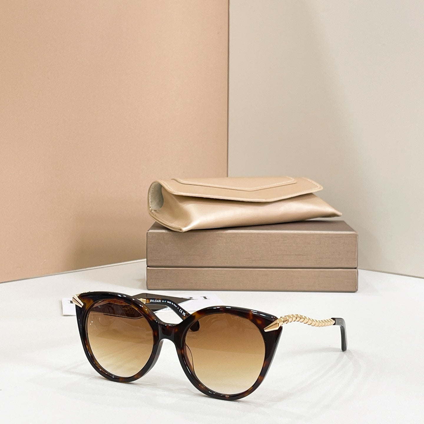 Brown tortoiseshell cat-eye sunglasses with gold chain arms and amber-tinted lenses
