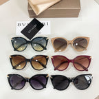 Assorted cat-eye sunglasses in black, tan, and burgundy with gold chain arms