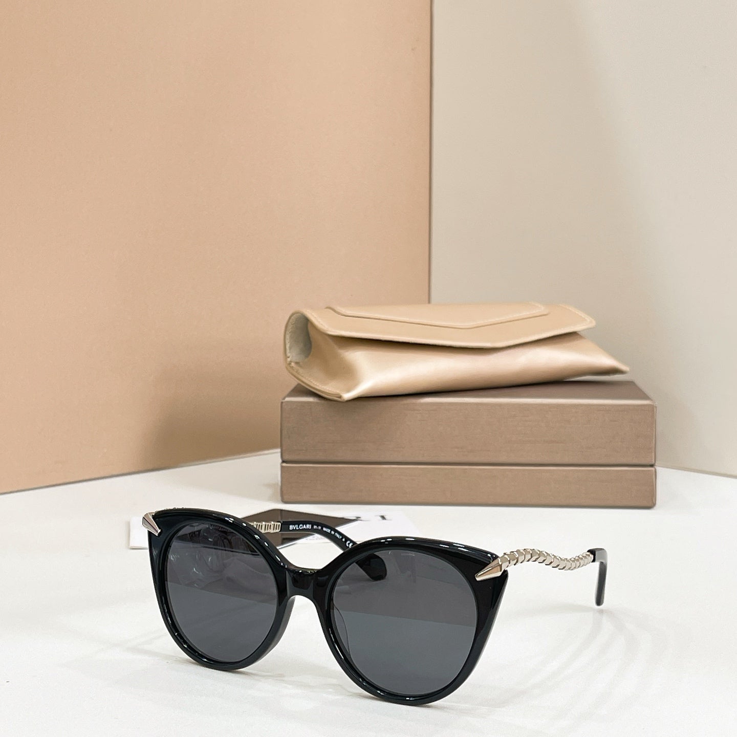 Black cat-eye sunglasses with gold chain arms and dark tinted lenses
