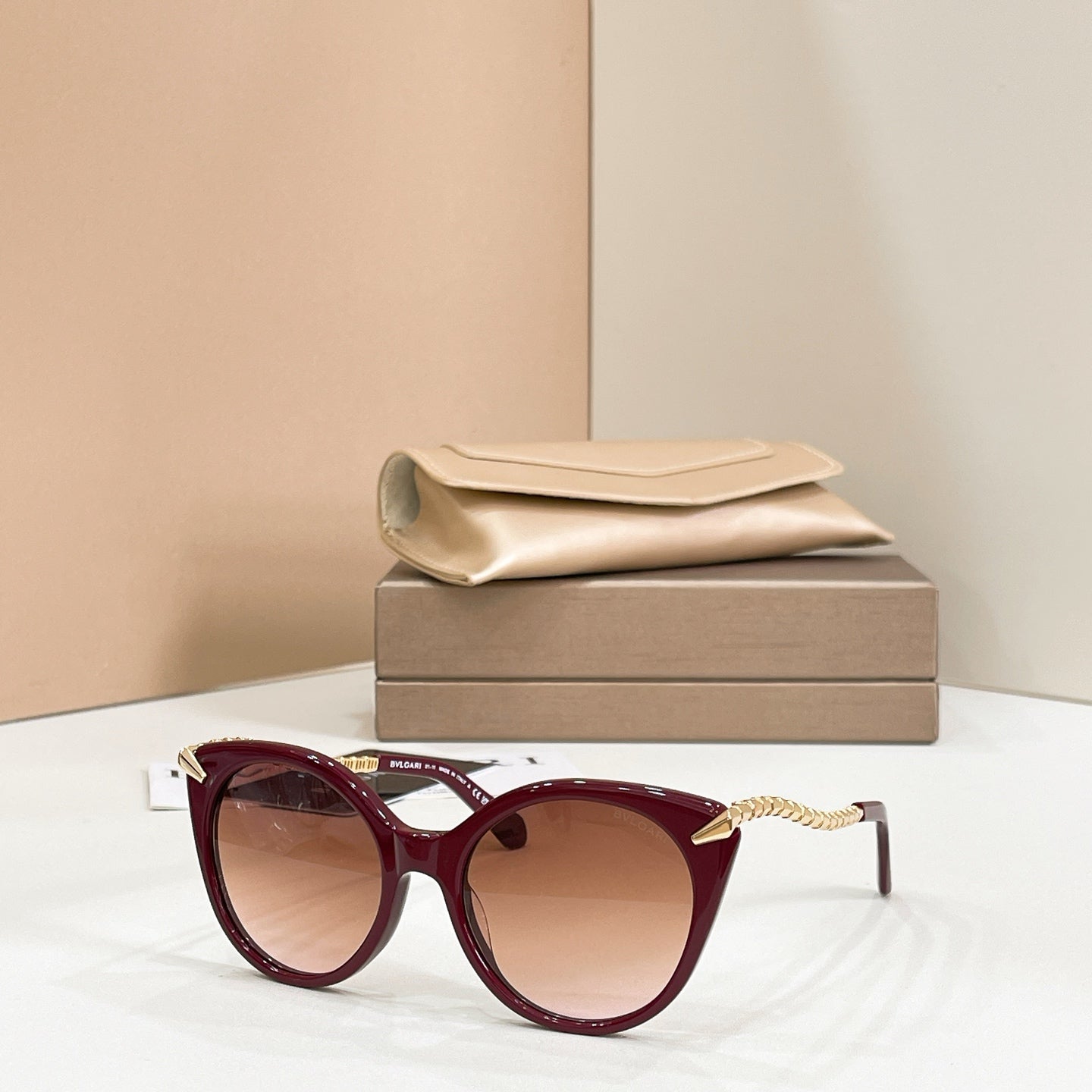 Burgundy cat-eye sunglasses with gold chain arms and tinted lenses