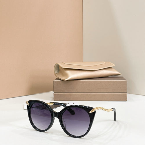 Black cat-eye sunglasses with gold chain arms and purple-tinted lenses