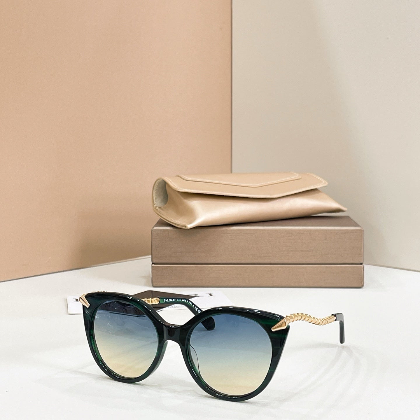 Dark green cat-eye sunglasses with gold chain arms and gradient tinted lenses
