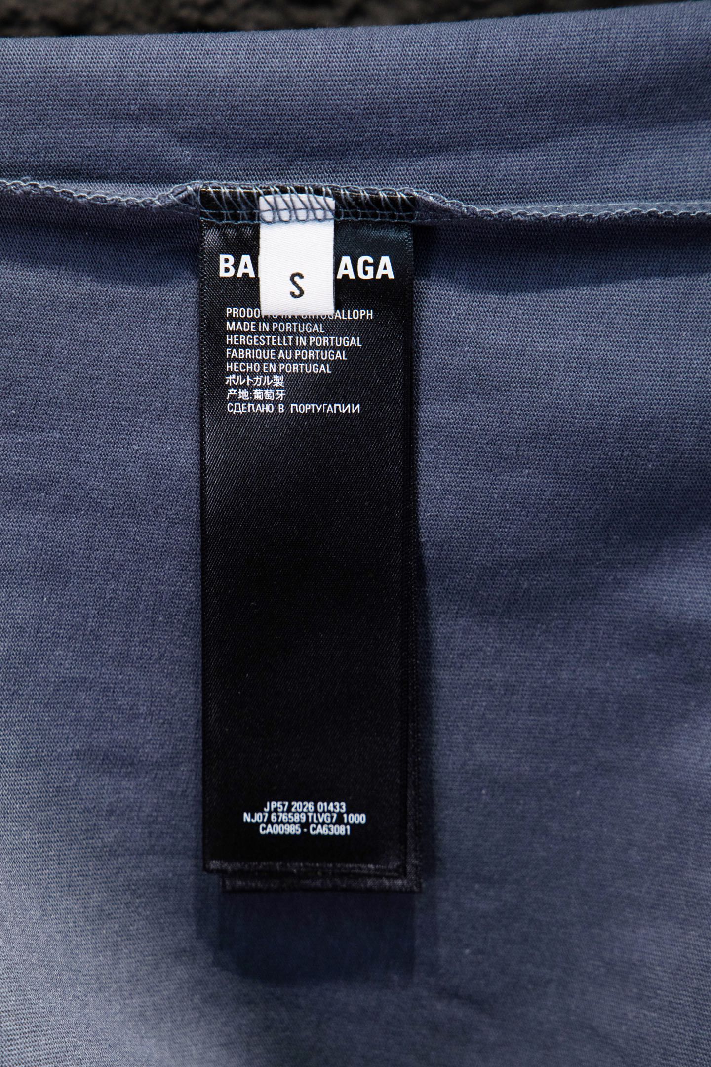 Balenciaga T-shirt inner care label tag on light blue fabric