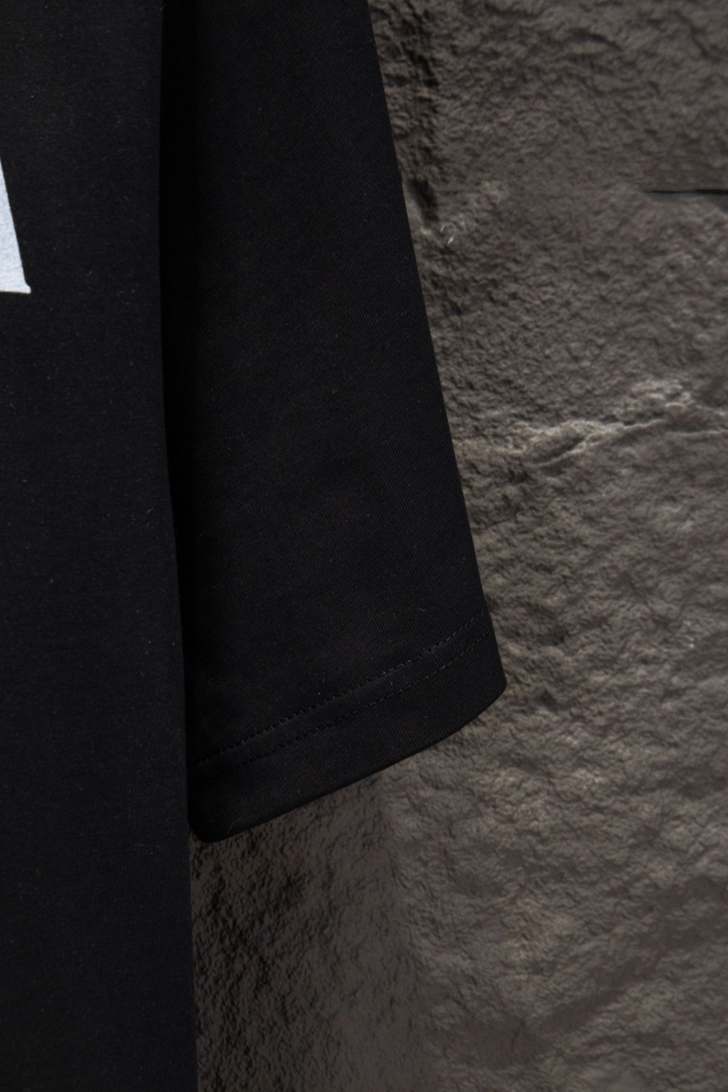 Black T-shirt sleeve and hem with visible stitching