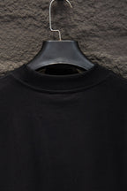 Black crew-neck T-shirt neckline close-up on hanger