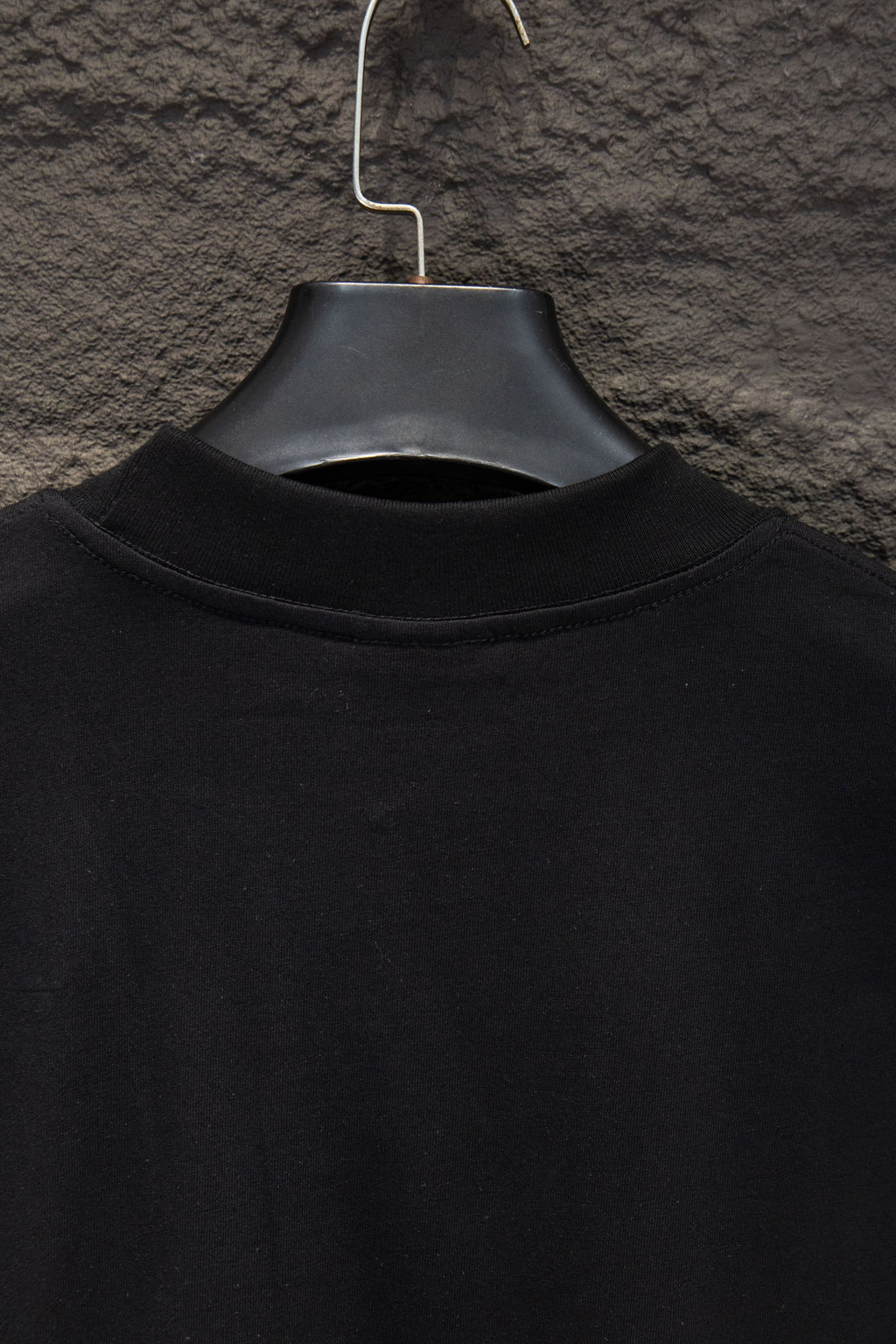 Black short-sleeve T-shirt collar view on hanger