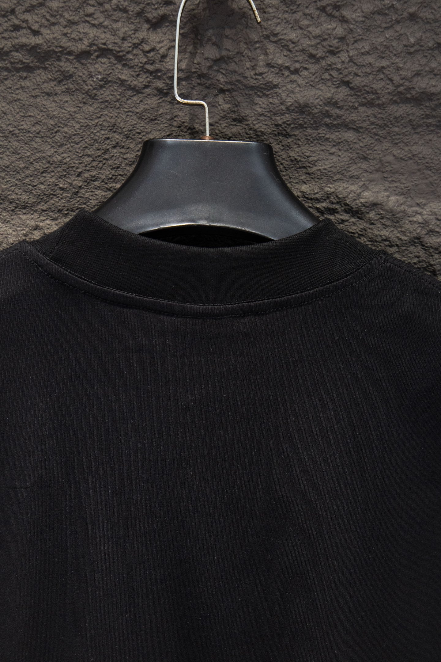 Black short-sleeve T-shirt collar view on hanger