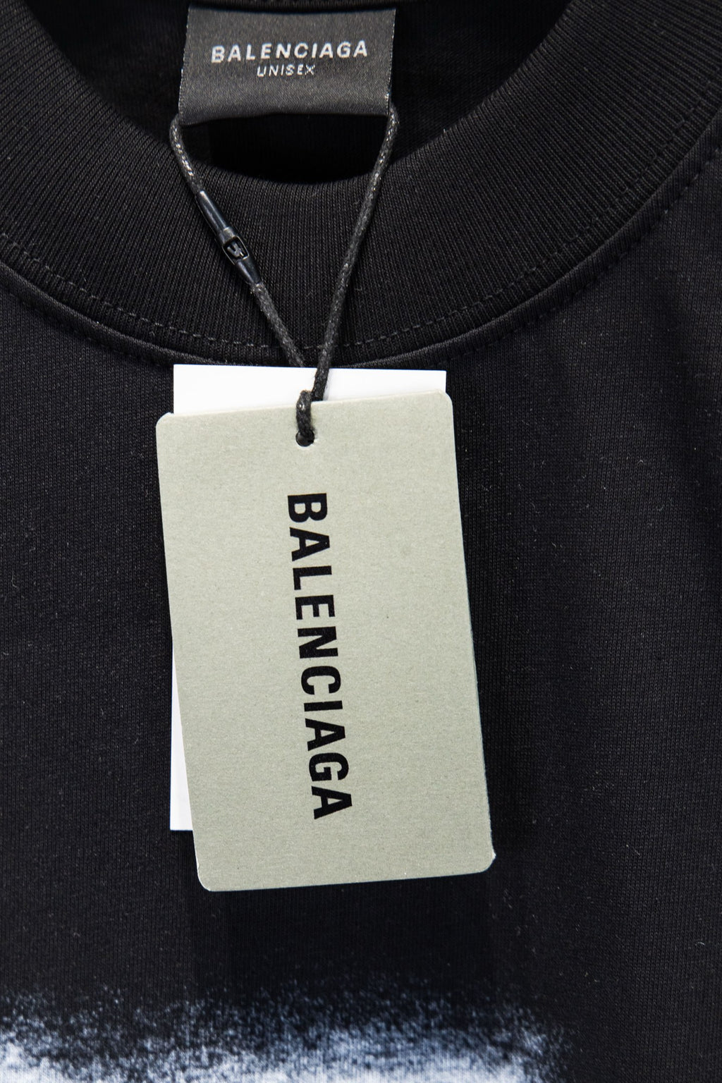 Black short-sleeve T-shirt with Balenciaga logo hang tag at neckline