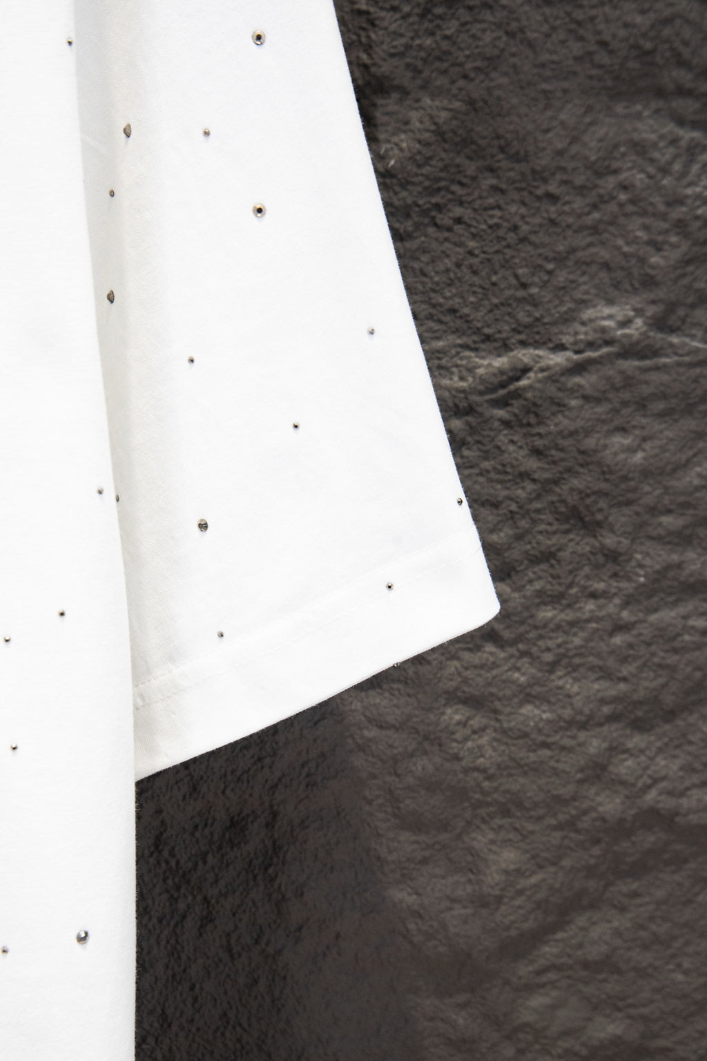 White short-sleeve shirt with stud-like dots and curved side hem