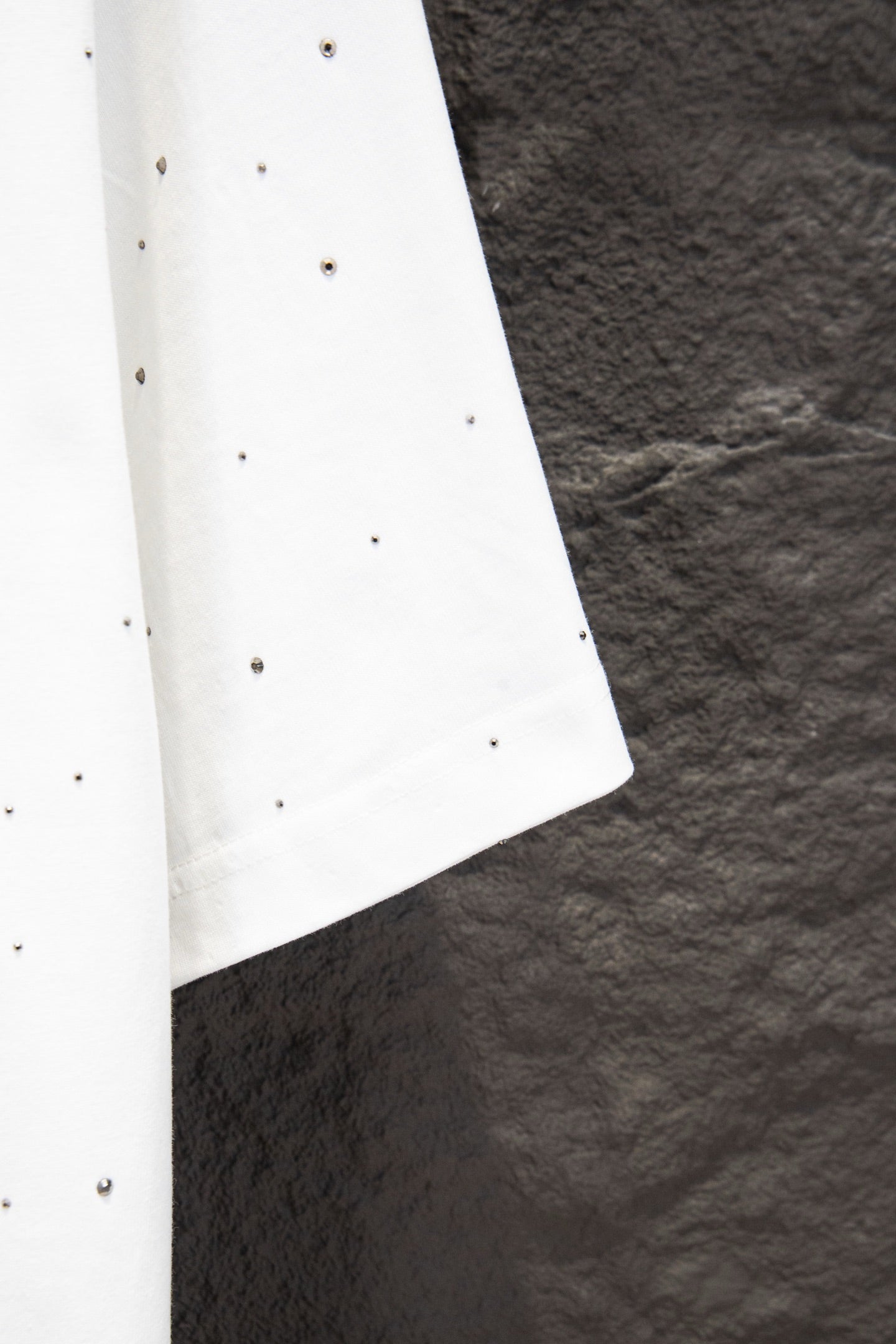 White short-sleeve shirt with stud-like dots and curved side hem