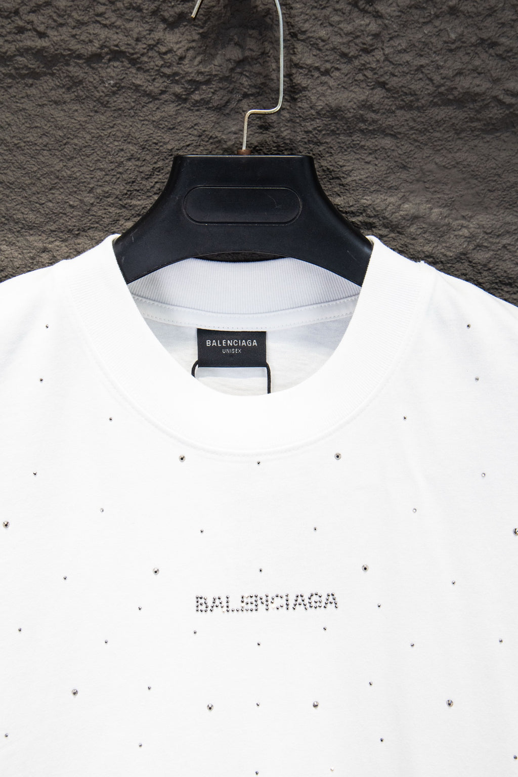 White crewneck shirt with black Balenciaga print at center collar and stud-like dots