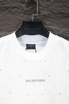 White crewneck shirt with black Balenciaga print at center collar and stud-like dots