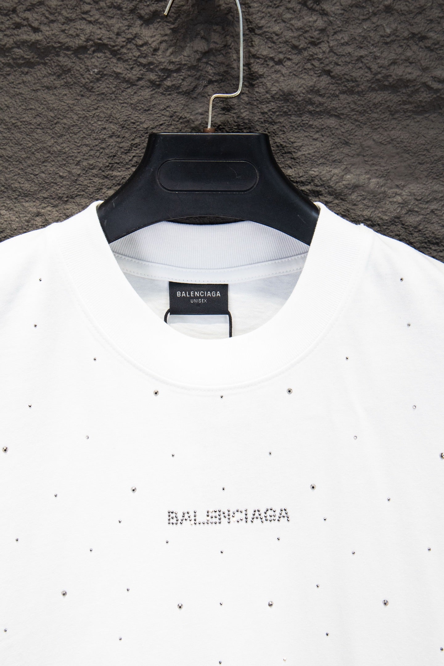 White crewneck shirt with black Balenciaga print at center collar and stud-like dots