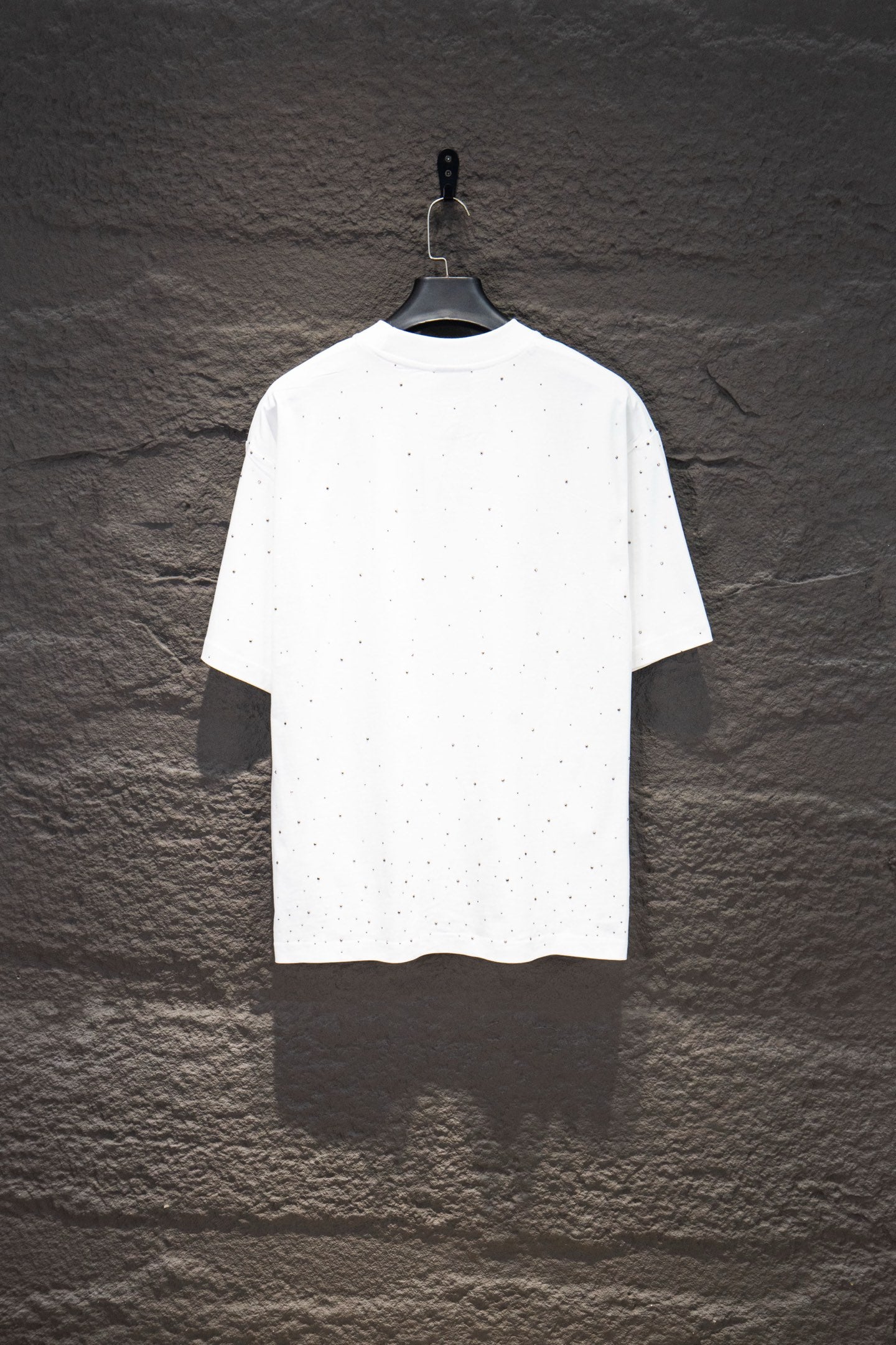 White short-sleeve crewneck shirt with scattered stud-like dots on the torso