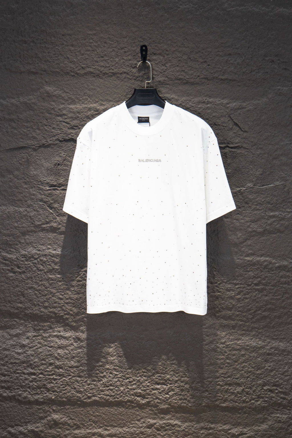 White short-sleeve crewneck shirt with tiny stud-like dots and small chest logo
