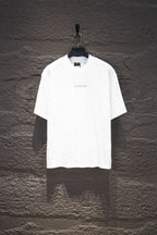 White short-sleeve crewneck shirt with tiny stud-like dots and small chest logo