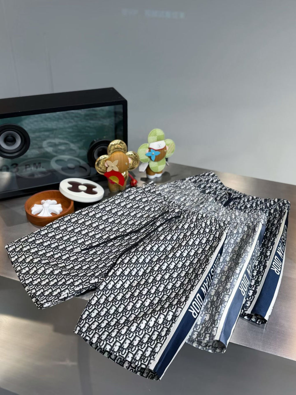 Logo-print pants with a dark blue waistband band, folded and neatly stacked