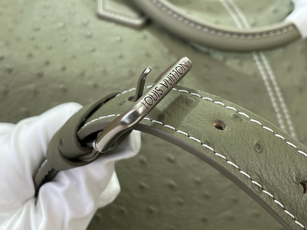Louis Vuitton olive green bag with stitched strap and metal clasp hardware