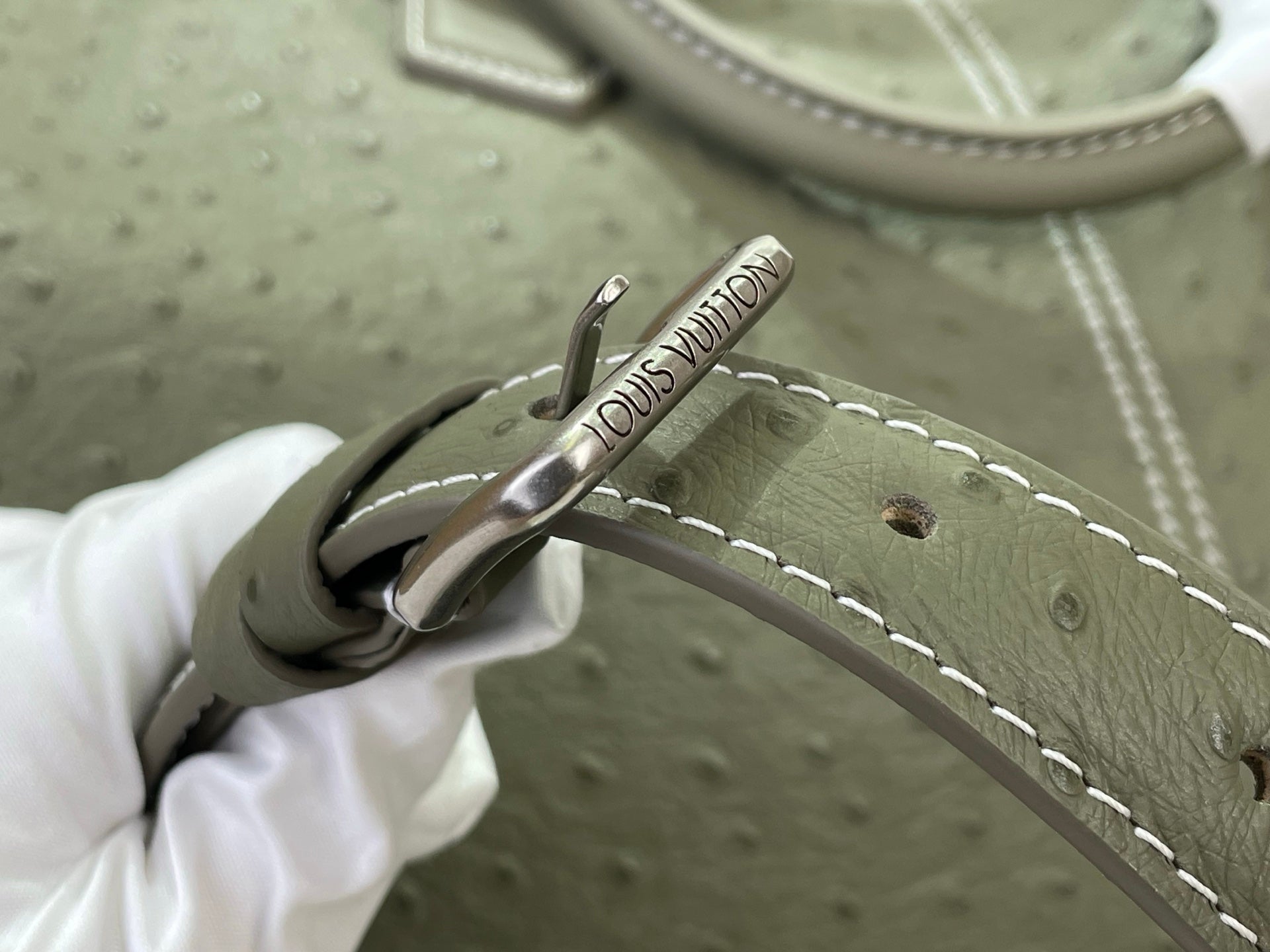 Louis Vuitton olive green bag with stitched strap and metal clasp hardware